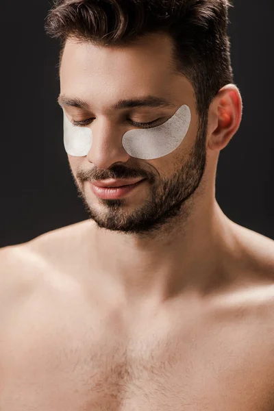 Сексуальный позитивный обнаженный мужчина с повязками на лице, изолированными от серого — стоковое фото