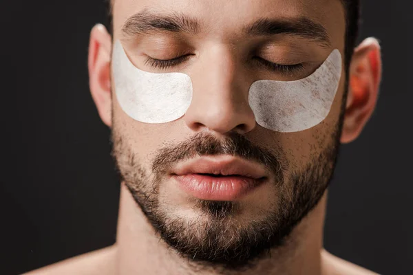 Bel homme avec des bandeaux oculaires sur le visage isolé sur le gris — Photo de stock