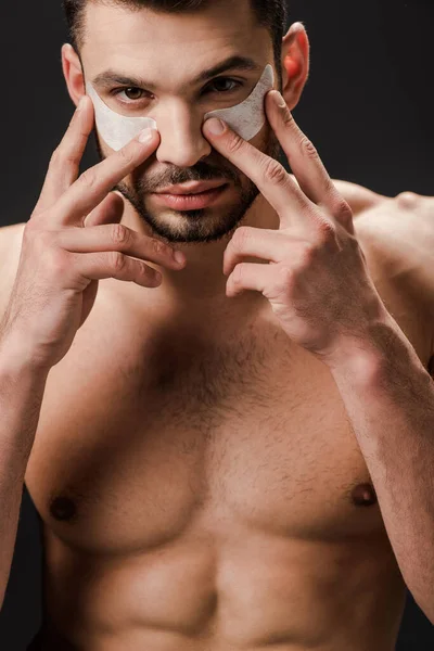 Sexy nude man applying eye patches on face isolated on grey — Stock Photo