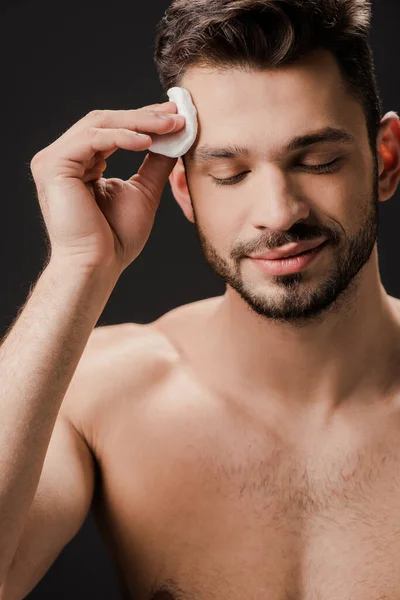 Souriant sexy nu homme à l'aide de coton cosmétique pad isolé sur noir — Photo de stock