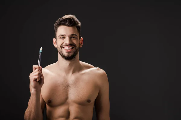 Sexy sonriente hombre desnudo con cepillo de dientes aislado en negro - foto de stock