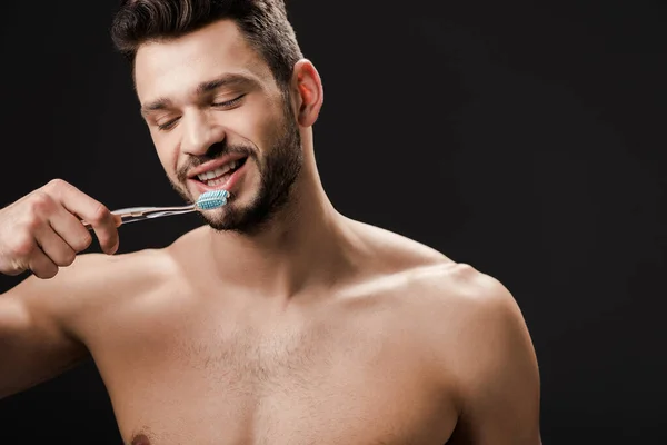 Homem nu positivo com escova de dentes isolado em preto — Fotografia de Stock