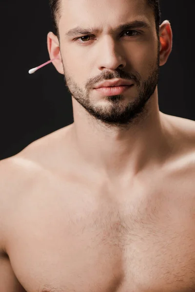 Красивый голый мужчина с мазком для ушей, изолированным на черном — стоковое фото