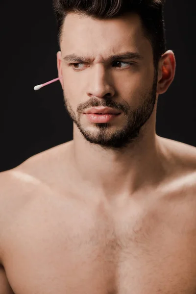 Hombre desnudo reflexivo con hisopo de oreja aislado en negro - foto de stock