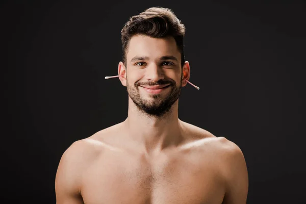 Smiling naked man with ear swabs isolated on black — Stock Photo