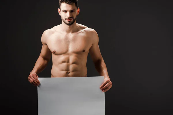 Sexy desnudo hombre sosteniendo en blanco cartel aislado en negro - foto de stock