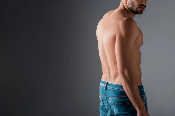 Vista ritagliata di uomo senza camicia in jeans su grigio — Foto stock