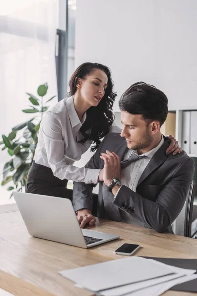 Secrétaire sexy étreignant beau patron tout en le séduisant au bureau — Photo de stock