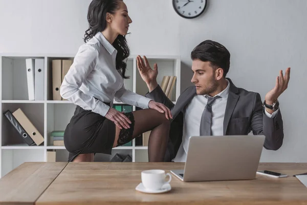 Сексуальна секретарка сидить на столі і показує її панчіх біля шокованого бізнесмена — стокове фото