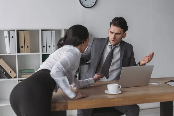 Sexy secretary touching tie of shocked businessman while seducing him in office — Stock Photo