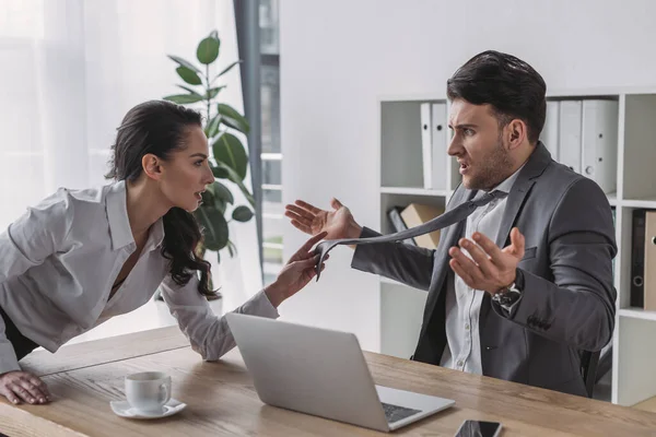 Secrétaire séduisant touchant cravate de l'homme d'affaires choqué tout en le séduisant dans le bureau — Photo de stock