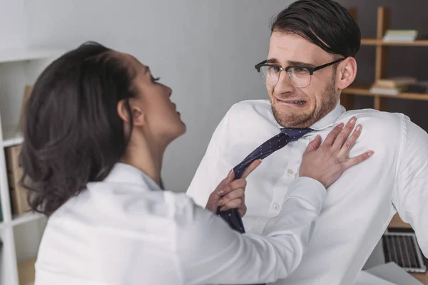 Seductora mujer de negocios tocando asustado colega mientras lo seduce en la oficina - foto de stock