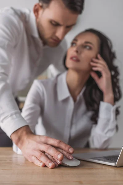 Selektiver Fokus des Geschäftsmannes, der die Hände der Sekretärin mit dem Computermund berührt — Stockfoto