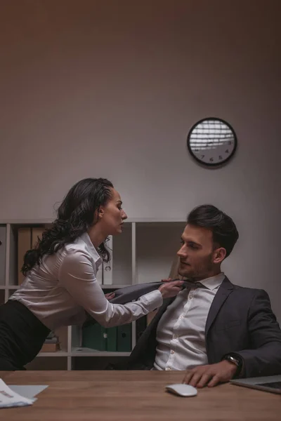 Atractiva, sensual secretaria tocando la corbata de guapo camarero - foto de stock