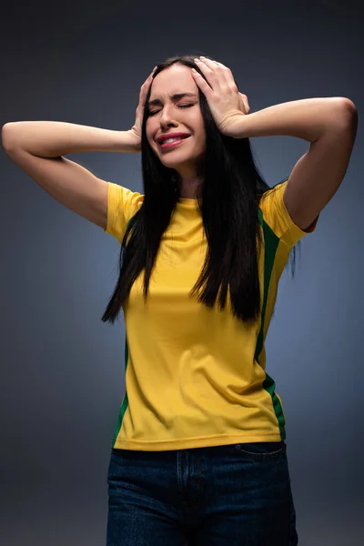 Stressed attractive young woman holding head on grey — Stock Photo