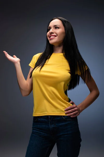 Positive female football fan gesturing on grey — Stock Photo