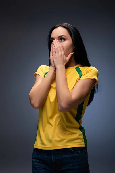 Перепуганная футбольная фанатка, покрывающая лицо серым — стоковое фото