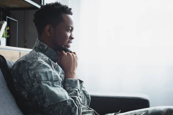 Emotional african american soldier in military uniform suffering from PTSD at home — Stock Photo