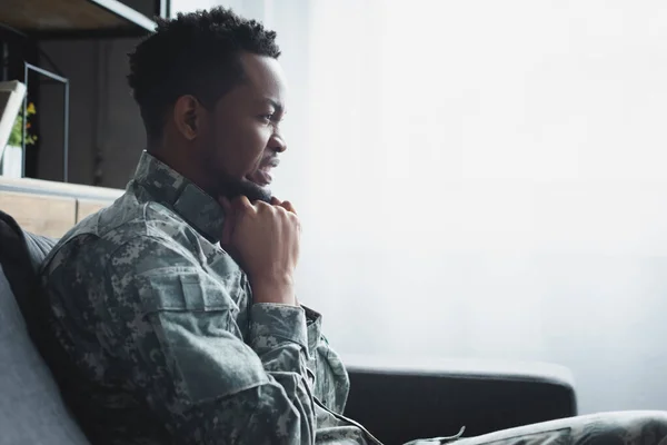 Soldat afro-américain émotionnel en uniforme militaire souffrant de TSPT à la maison — Photo de stock