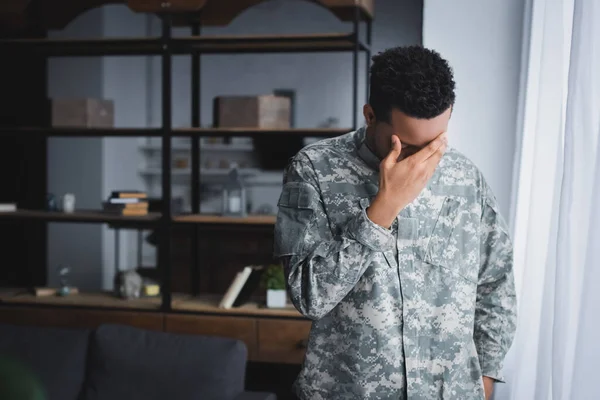 Soldado afro-americano estressado em uniforme militar sofrendo de TEPT em casa — Stock Photo