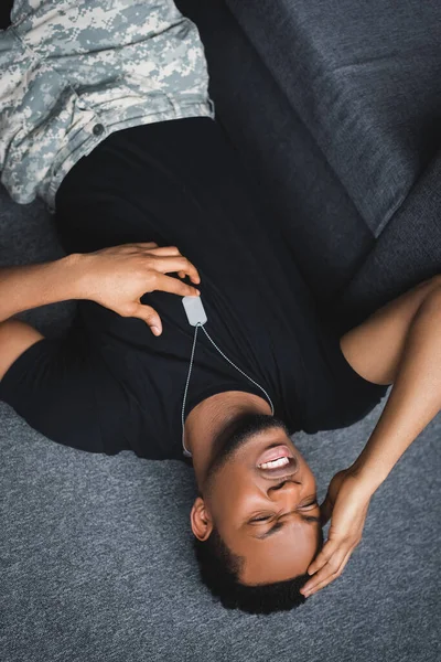 Stressed african american soldier with army badge having panic attack at home, suffering from PTSD — Stock Photo