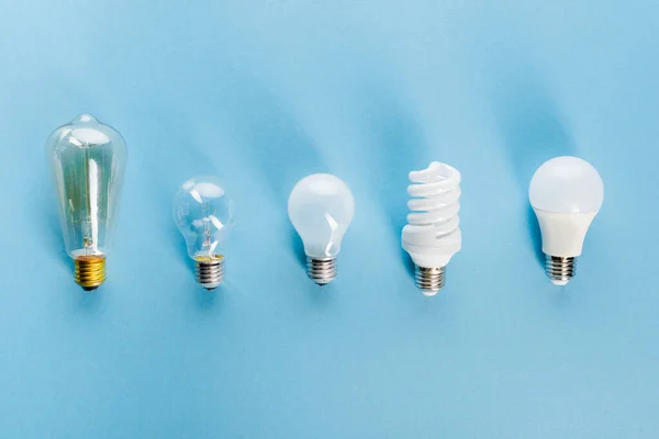 Top view of light bulbs on blue, evolution concept — Stock Photo