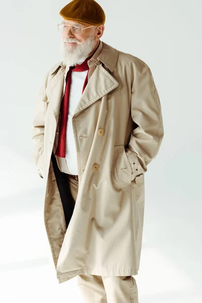 Bonito homem idoso de casaco e boina olhando para o fundo branco — Fotografia de Stock