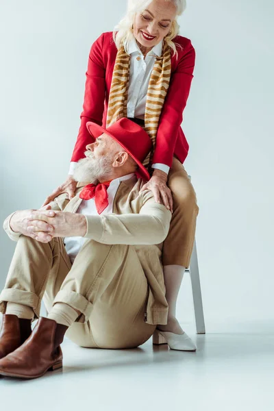 Smiling elderly woman hugging stylish man on white background — Stock Photo