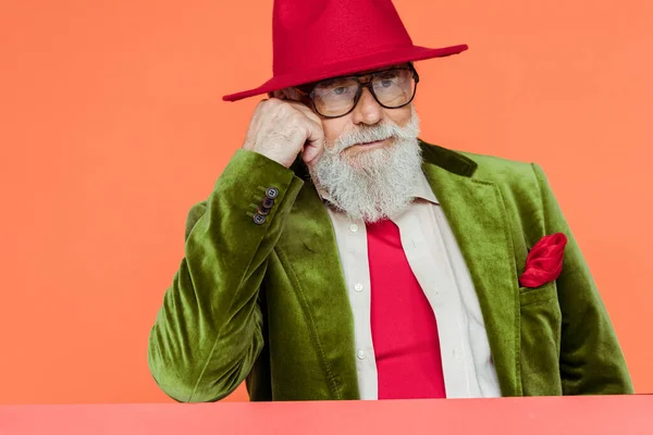 Homem sênior elegante em chapéu vermelho olhando para longe isolado em coral — Fotografia de Stock