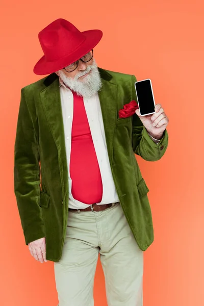 Elegante uomo anziano guardando smartphone isolato su corallo — Foto stock