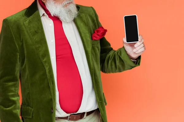 Cropped view of stylish senior man holding smartphone with blank screen isolated on coral — Stock Photo