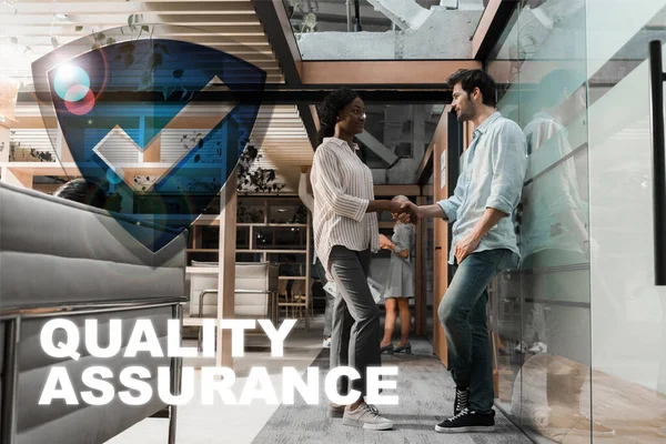 Young african american businesswoman shaking hands with handsome colleague, quality assurance illustration — Stock Photo