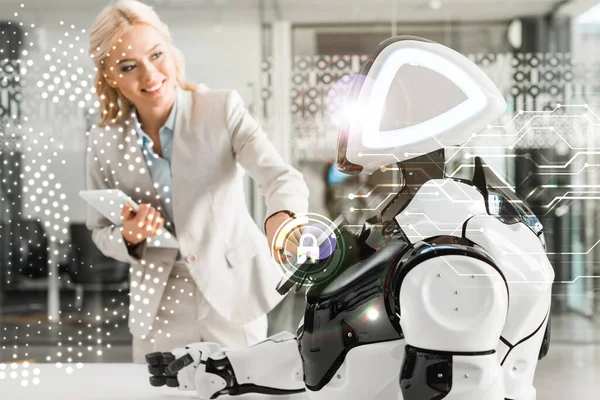 Donna d'affari sorridente che opera robot mentre tiene tablet digitale, illustrazione di sicurezza informatica — Foto stock