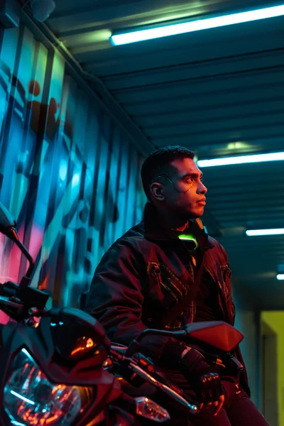 Selective focus of mixed race cyberpunk player near motorcycle — Stock Photo
