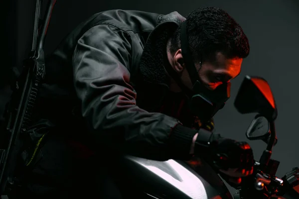 Selektiver Fokus der gefährlichen Mixed Race Cyberpunk-Spieler in Maske Motorrad fahren auf grau — Stockfoto