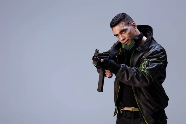 Schöner bi-rassischer Cyberpunk-Spieler mit Waffe in grau isoliert — Stockfoto