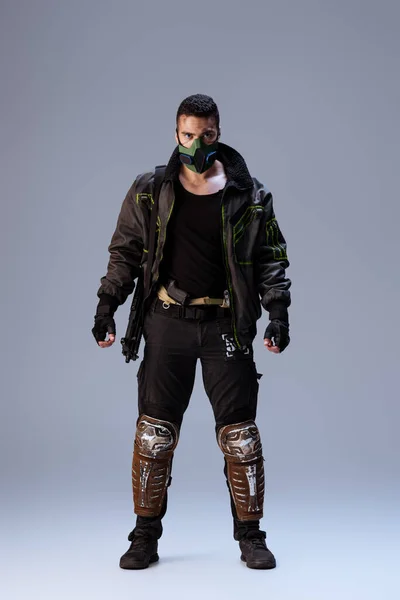 Jogador cyberpunk de raça mista em máscara em pé sobre cinza — Fotografia de Stock
