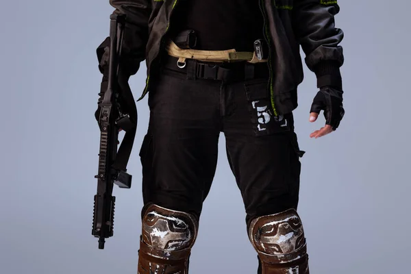Vista cortada do jogador cyberpunk segurando arma enquanto estava isolado em cinza — Fotografia de Stock