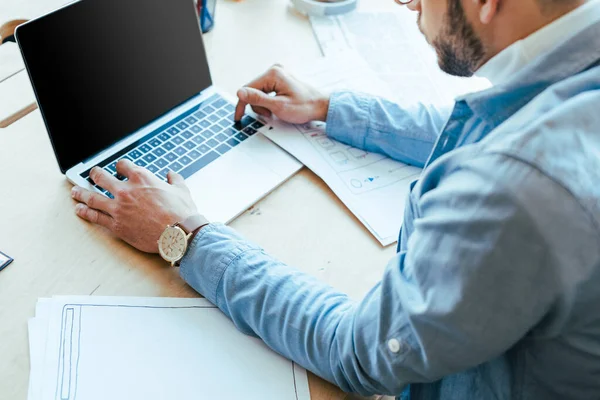 Обрезанный вид ИТ-работника с помощью ноутбука за столом в коворкинг-пространстве — стоковое фото
