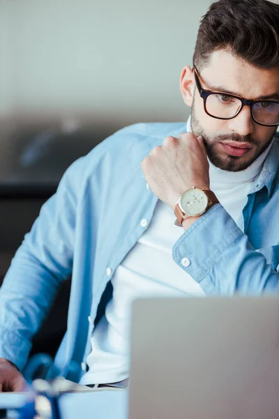 Enfoque selectivo del trabajador de TI concentrado en gafas - foto de stock