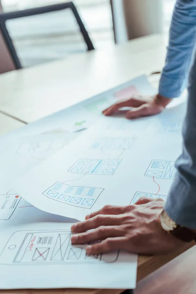 Vue partielle du concepteur de l'interface utilisateur avec des papiers tissés à la table — Photo de stock