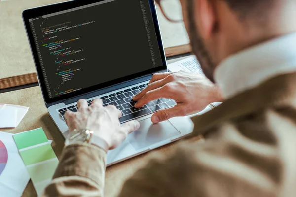 Cropped view of developer using laptop at table — Stock Photo