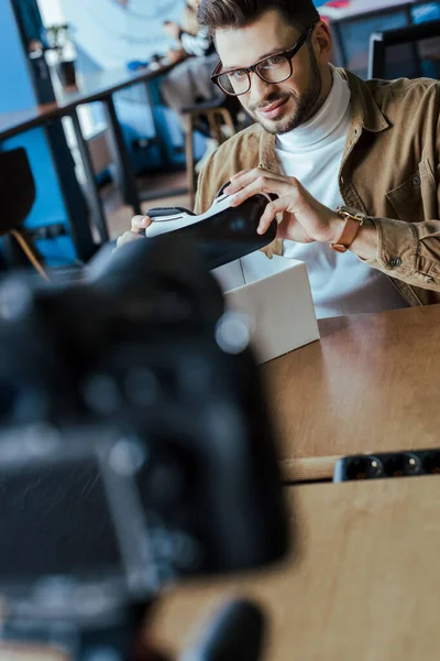 Selective focus of blogger holding virtual reality headset at table in coworking space — Stock Photo