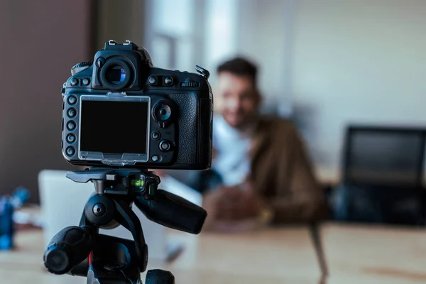 Selective focus of silhouette of blogger in front of digital camera — Stock Photo