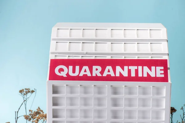 Carton hospital model with quarantine lettering isolated on blue — Stock Photo