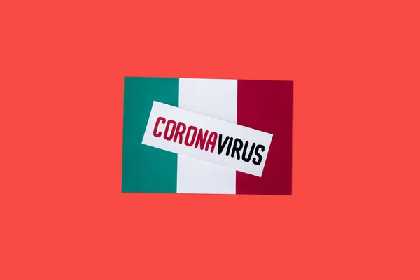 Vue du haut du drapeau italien avec lettrage coronavirus isolé sur rouge — Photo de stock