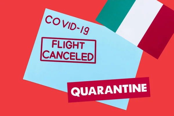 Top view of blue envelope with covid-19, flight canceled and quarantine lettering near flag of italy isolated on red — Stock Photo