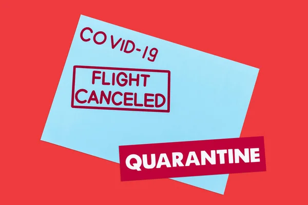 Top view of blue envelope with covid-19, flight canceled and quarantine lettering isolated on red — Stock Photo
