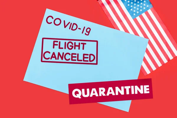 Vista superior do envelope azul com covid-19, voo cancelado e letras de quarentena perto da bandeira da América isolado em vermelho — Fotografia de Stock
