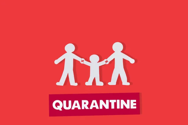 Top view of paper family with holding hands warning near quarantine lettering isolated on red — Stock Photo